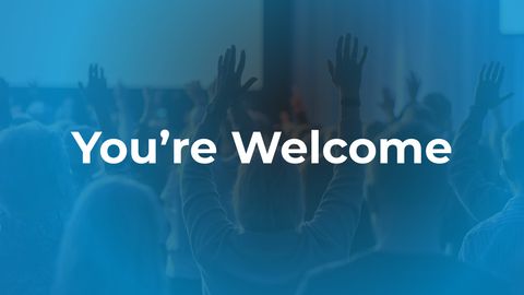 Worshippers with hands raised at a GraceLink Church service, with the words: You're Welcome